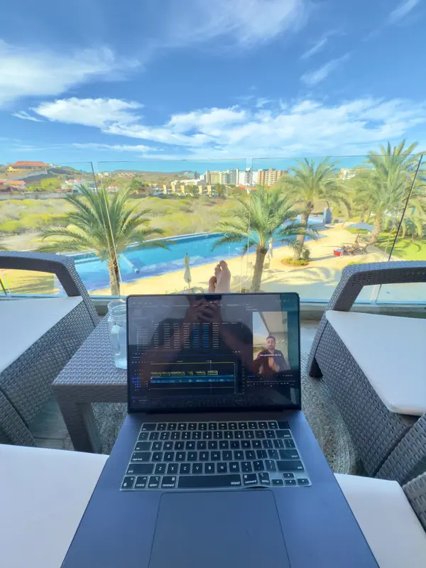 Patrick trabajando con su laptop en una terraza con piscina en Margarita, Venezuela